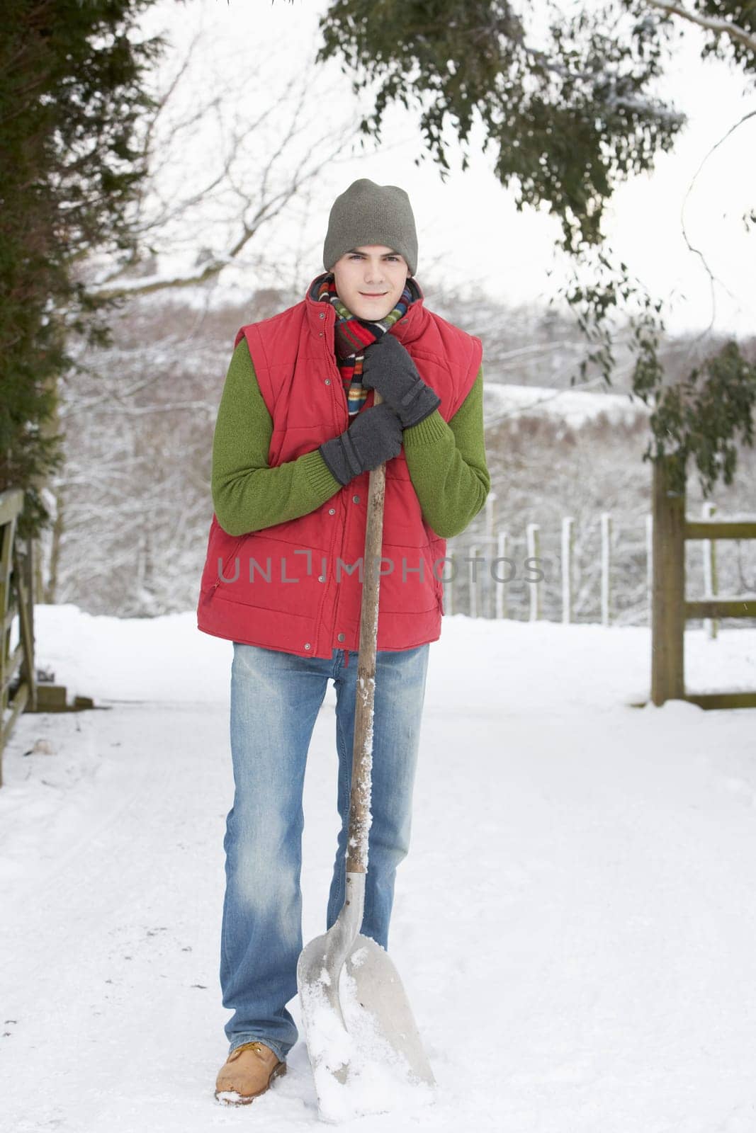 Young Man Clearing Snow From Drive