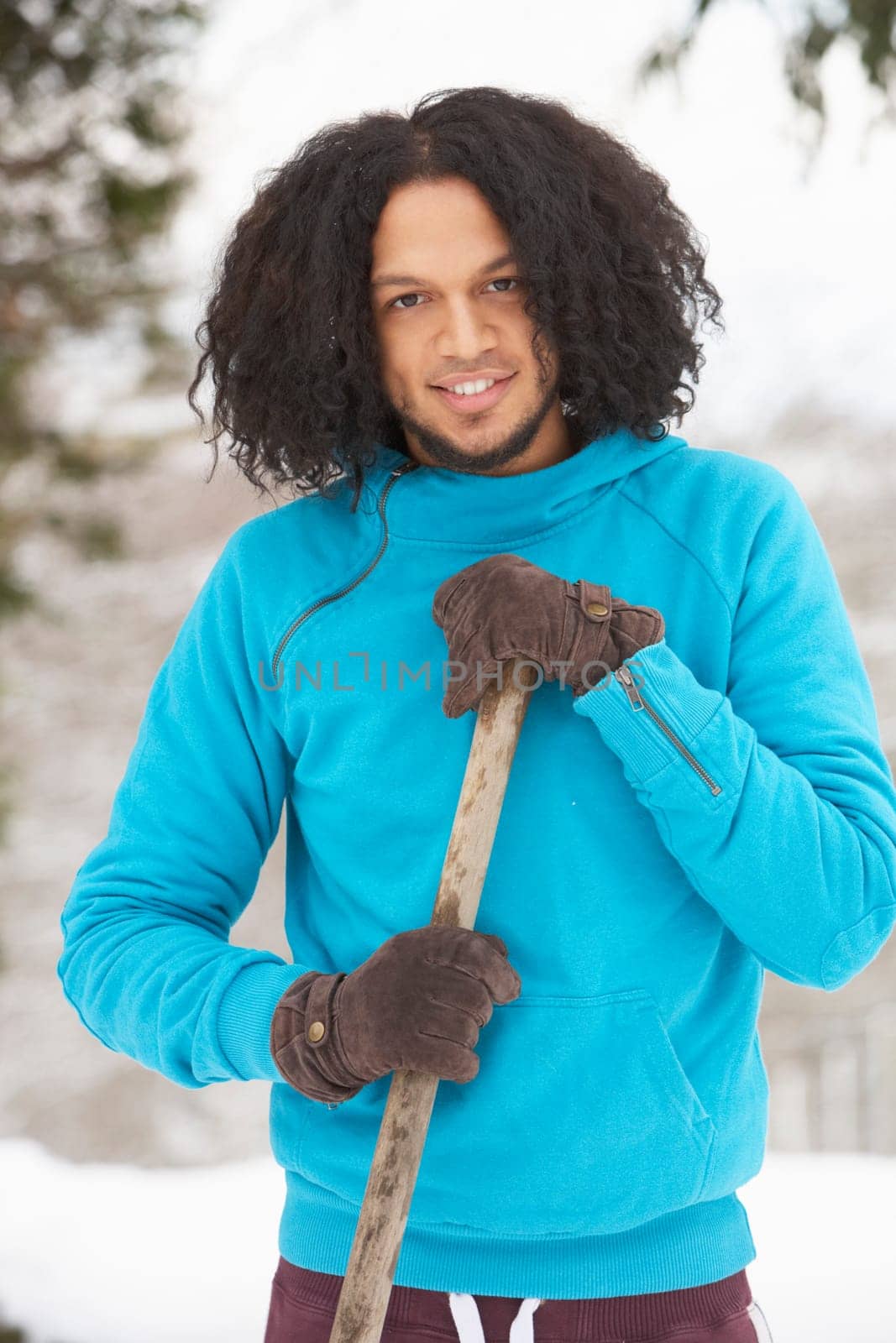 Young Man Clearing Snow From Drive