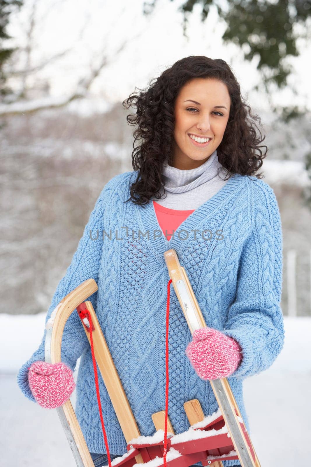 Woman Holding Sledge In Snowy Landscape
