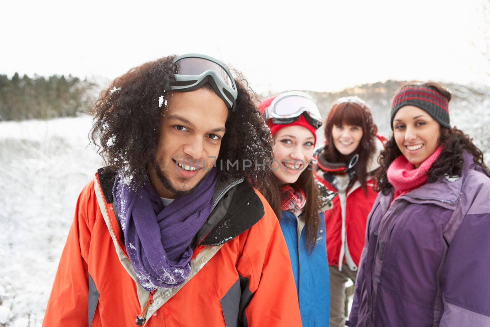 Group Of Teenage Friends Having Fun In Snowy Landscape Wearing Ski Clothing
