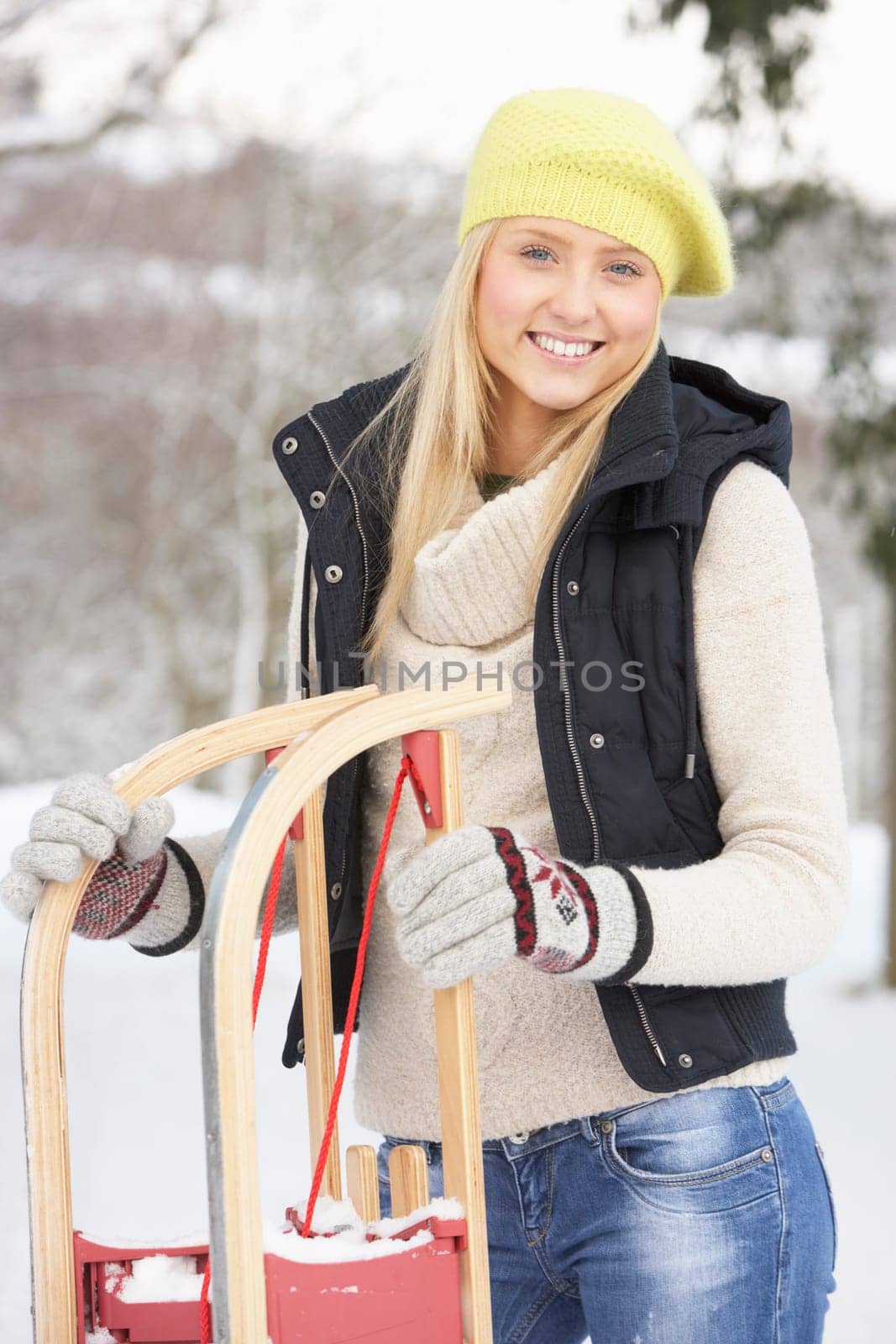 Teenage Girl Holding Sledge In Snowy Landscape