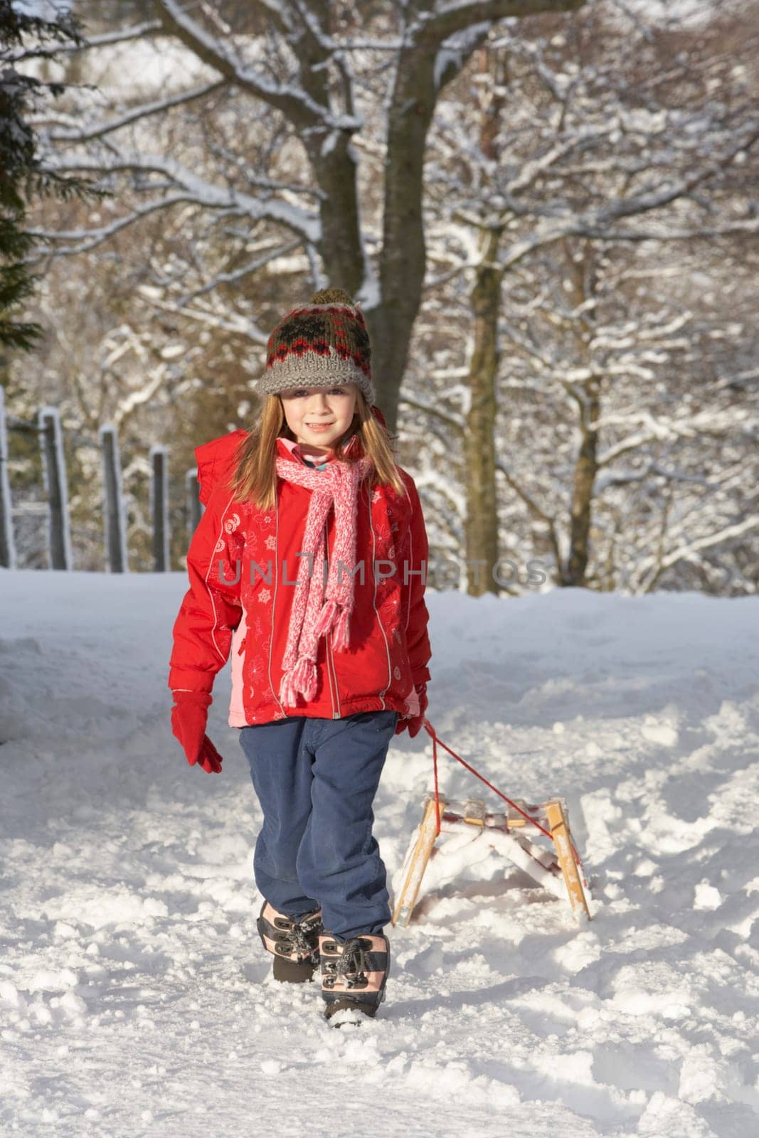 Young Girl Pulling Sledge Through Snowy Landscape