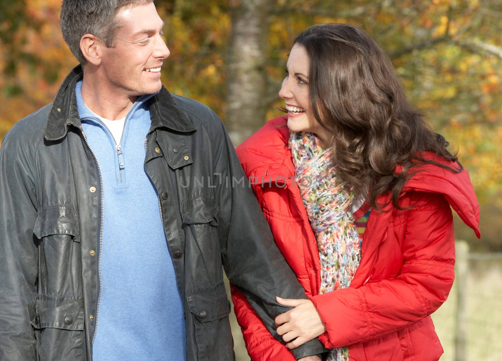 Young Couple Walking Through Autumn Park