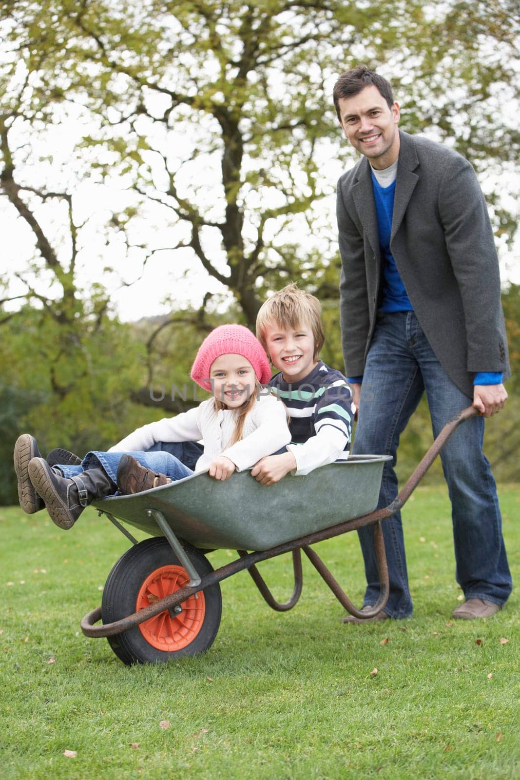 Father Giving Children Ride In Wheelbarrow