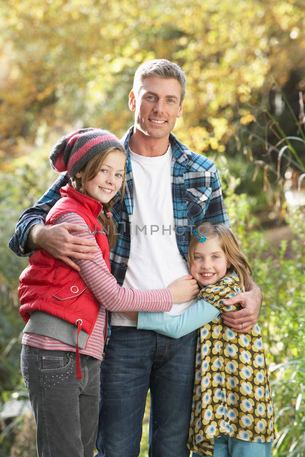 Father And Children Standing Outdoors On Wooden Walkway In Autumn Landscape