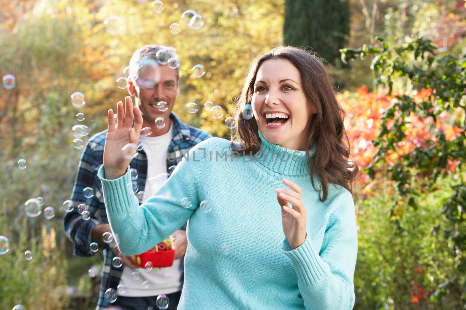 Couple Outdoors In Autumn Landscape With Bubble Machine