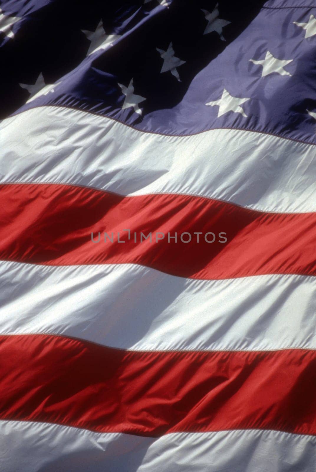A closeup of the flag of the United States blowing in the wind. Vertical shot.