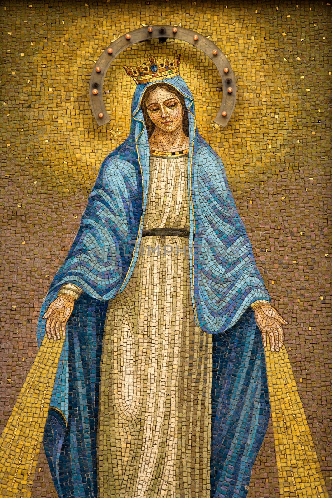 Mosaic of the Virgin Mary wearing a crown with device to give off light at night. Vertical shot.