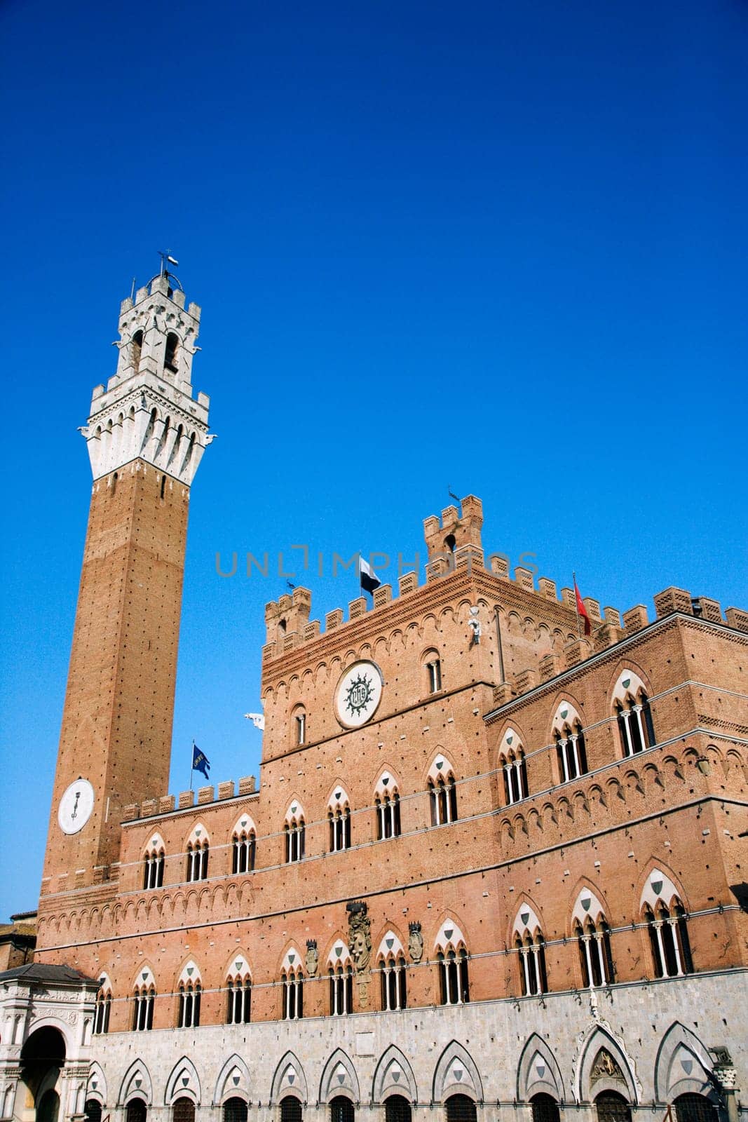 Low angle view of the bell tower of the Palazzo Pubblico, at the Piazzo del Campo, Siena, Italy. Vertical shot.