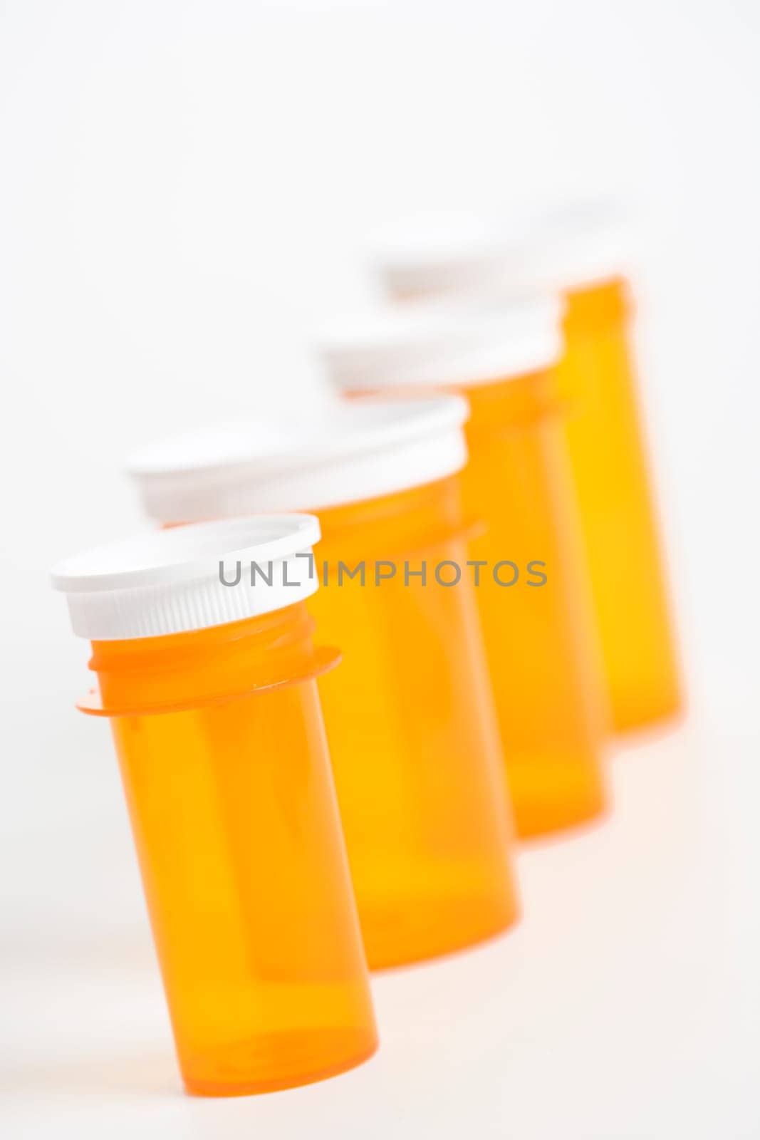 Yellow medicine bottles lined up in a row. Vertical shot. Isolated on white.
