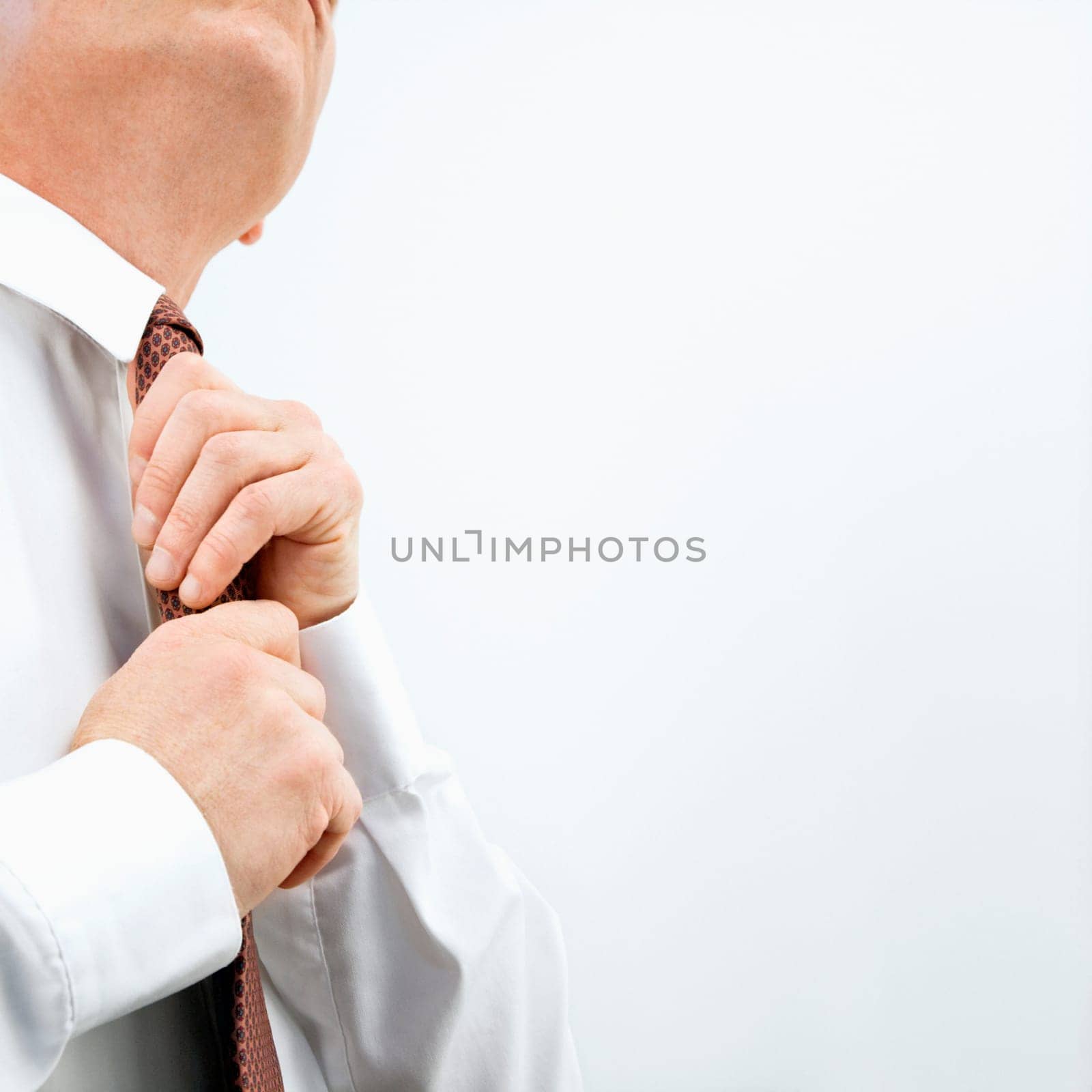 Caucasian middle aged businessman fixing necktie.