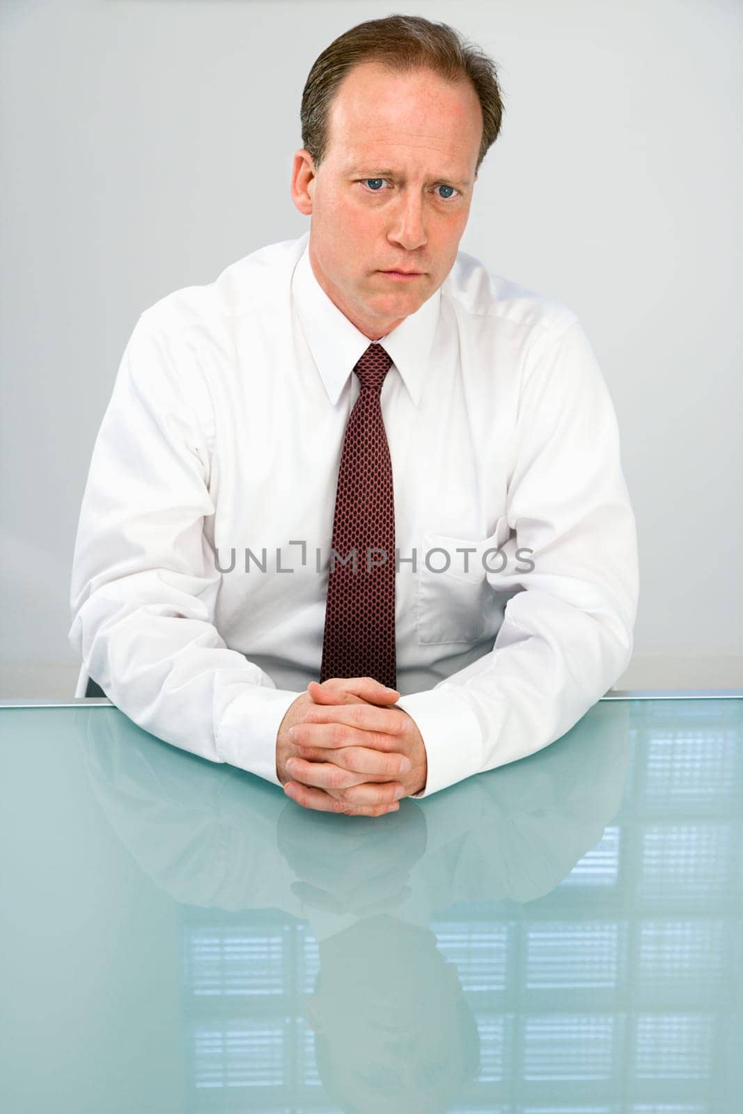 Portrait of Caucasian middle aged businessman sitting at desk.