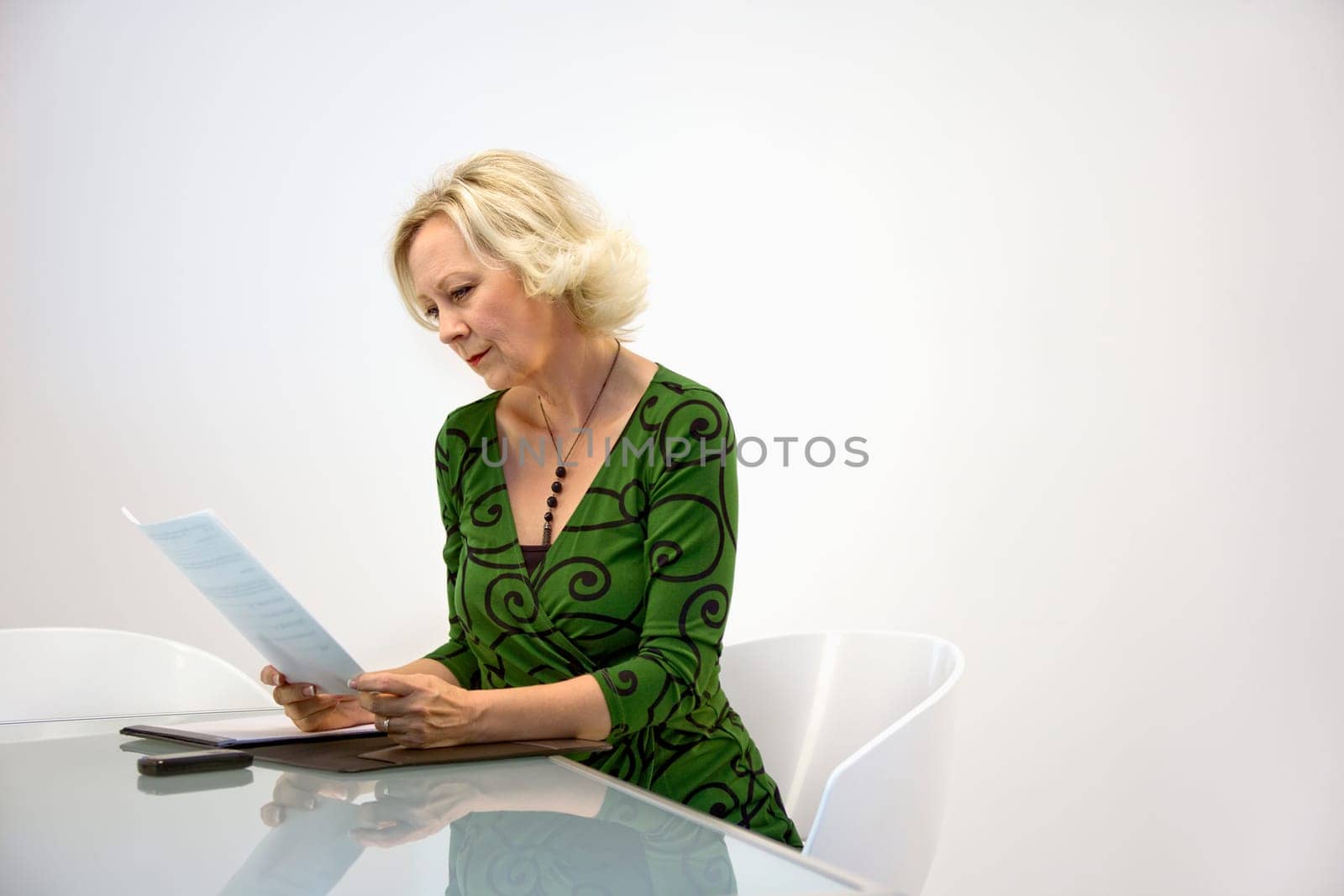 Caucasian middle aged businesswoman sorts through paperwork.