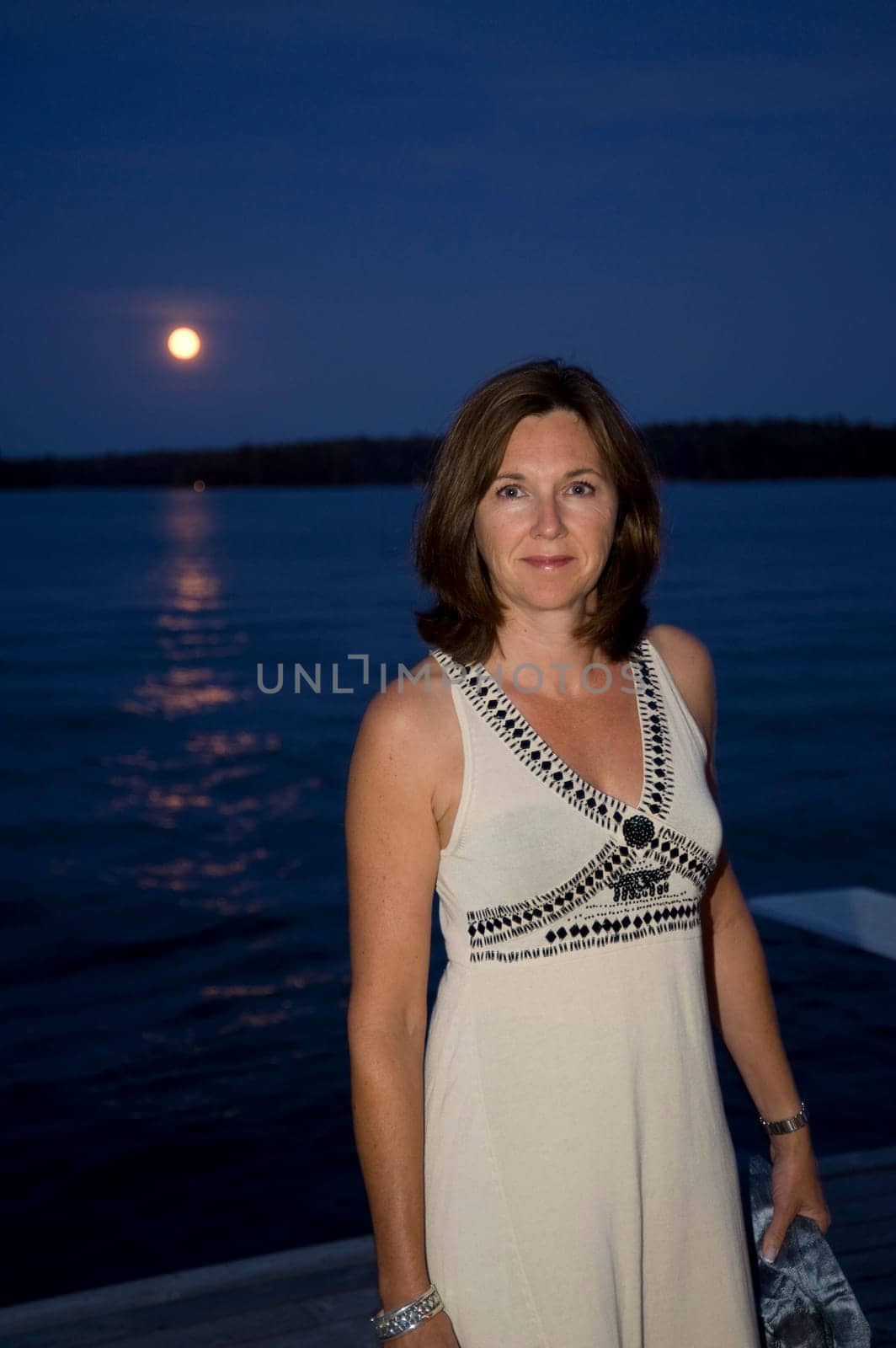 Woman on dock at night, Lake of the Woods, Ontario, Canada
