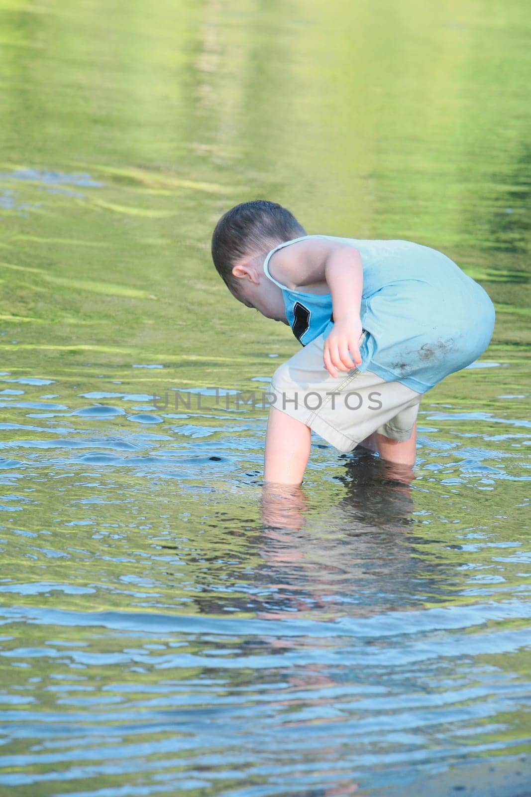 a young boy playing in the shallow water