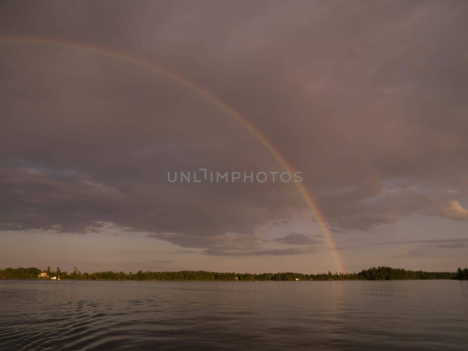 Rainbow over lake shoreline, Lake of the Woods, Ontario, Canada