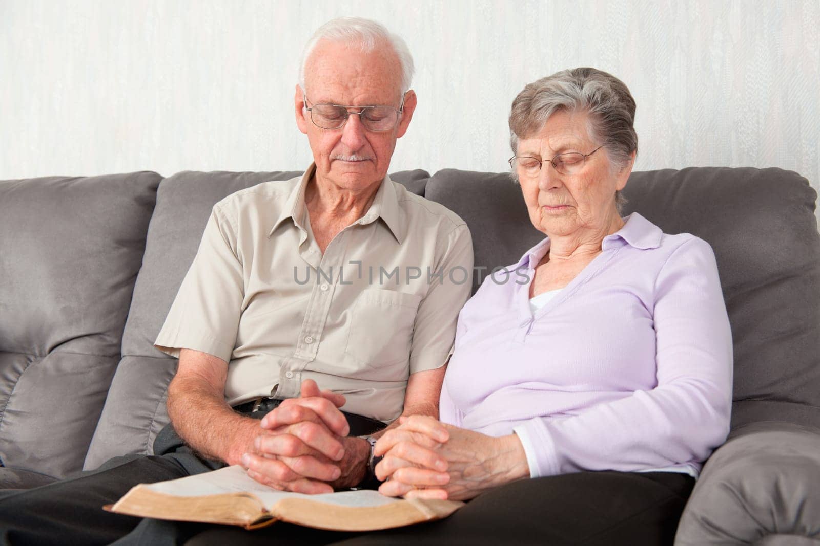 An elderly couple having worship with the Bible