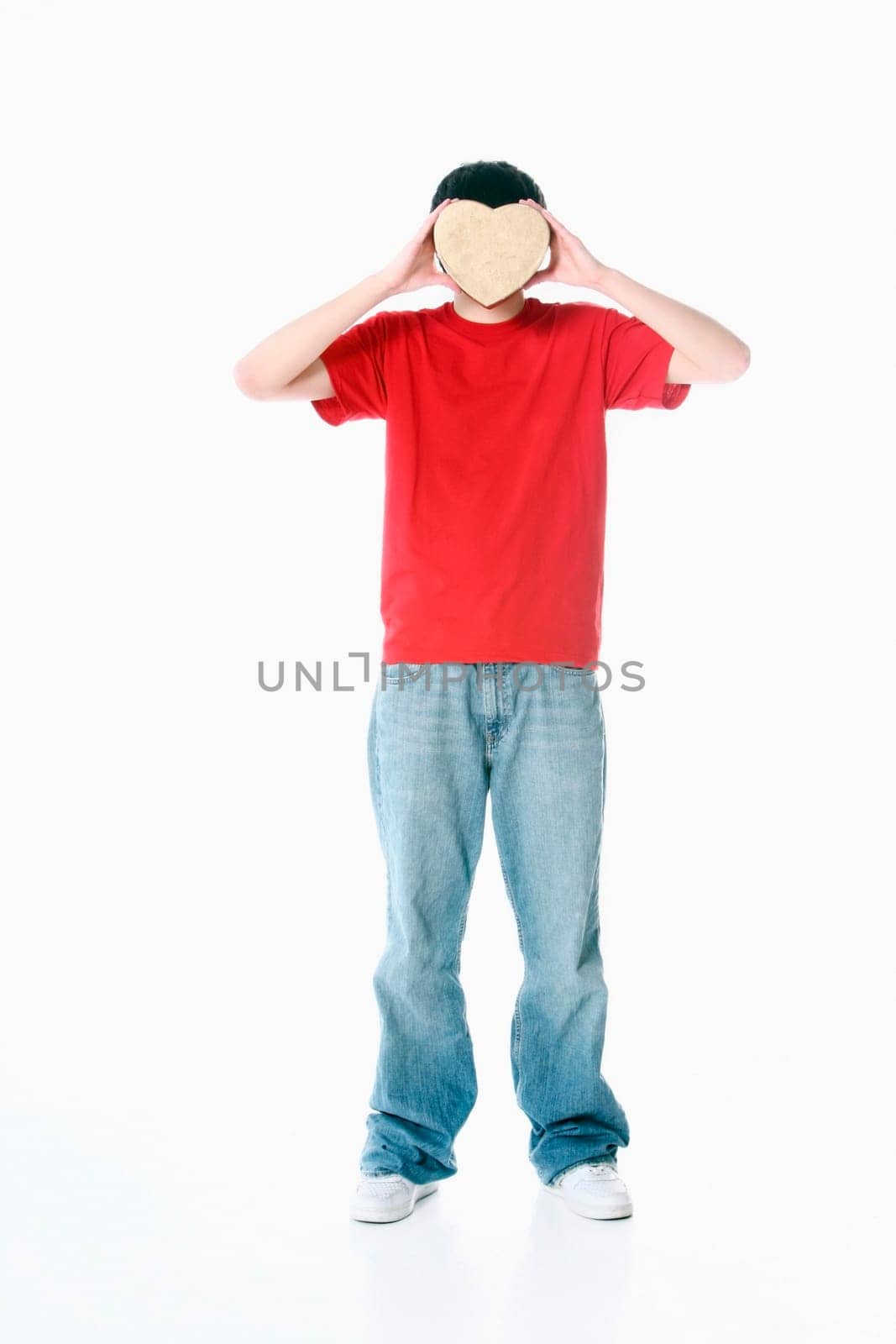 a boy with a heart covering his face