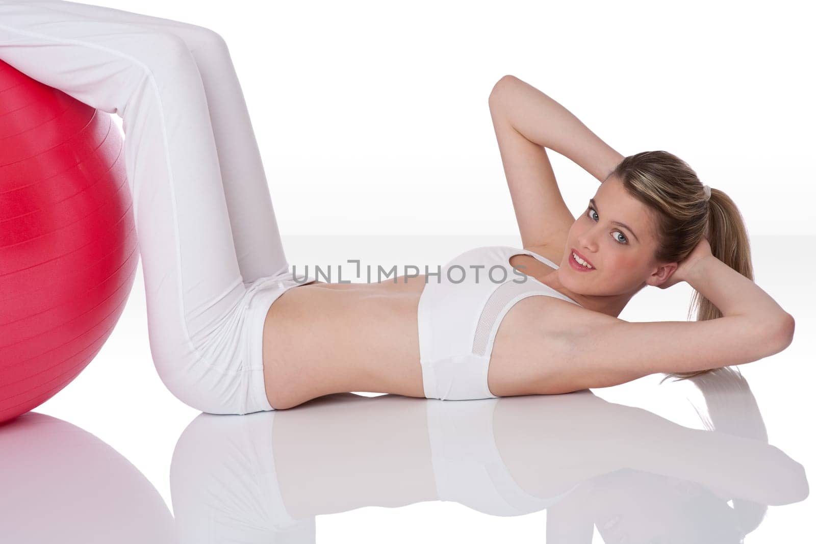 Fitness - Young woman with exercise ball on white