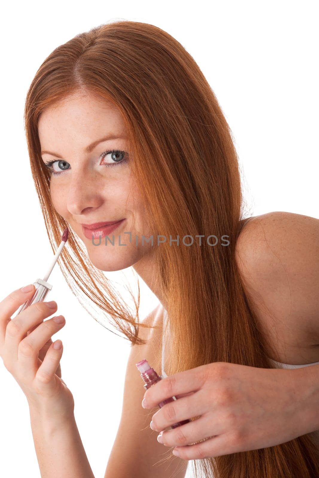 Body care - young woman apply lip gloss