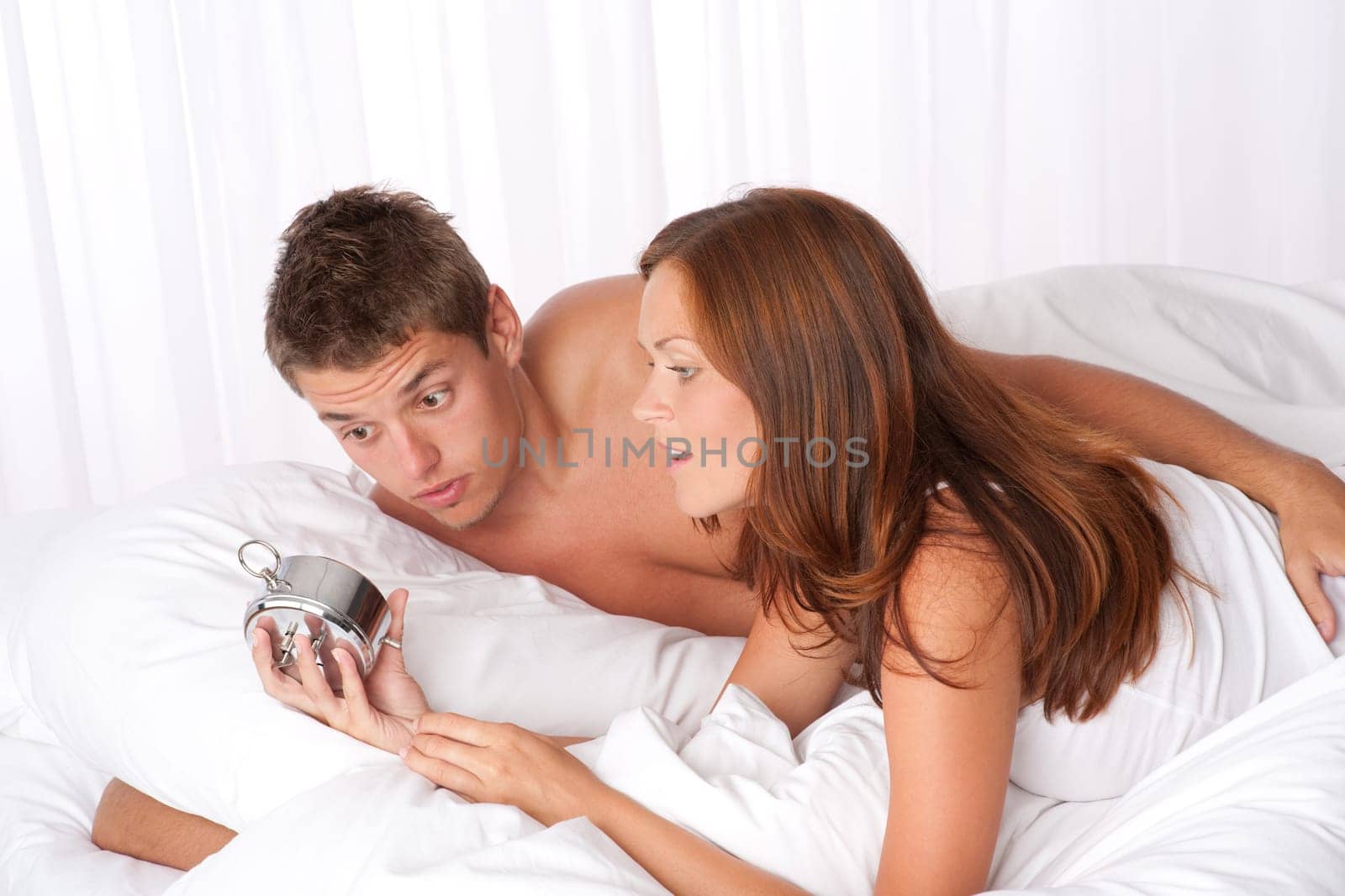 Young couple overslept, wake up in bed