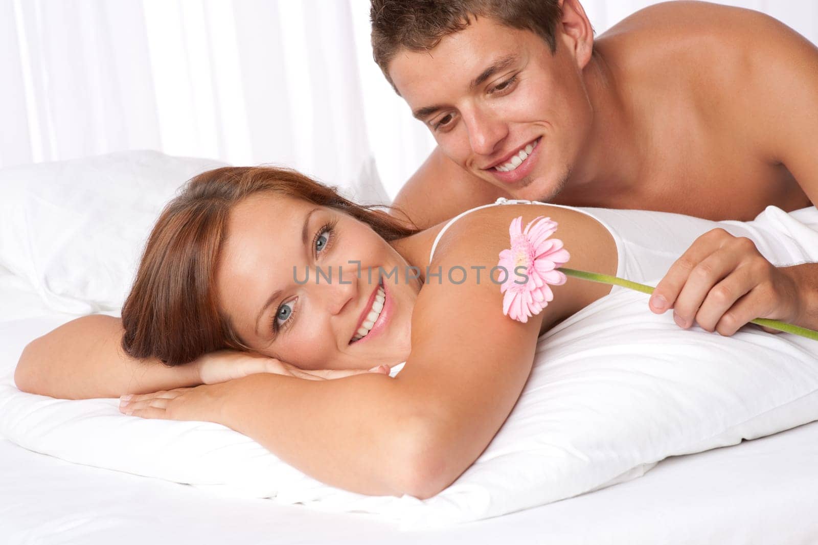 Honeymoon - Young couple embrace in bed