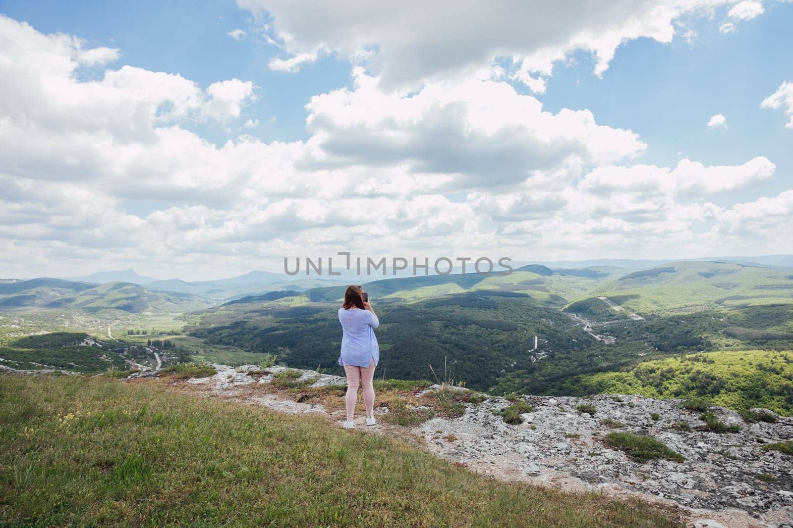 a woman on the mountain looks into the distance admiring nature journey hiking by Simakov