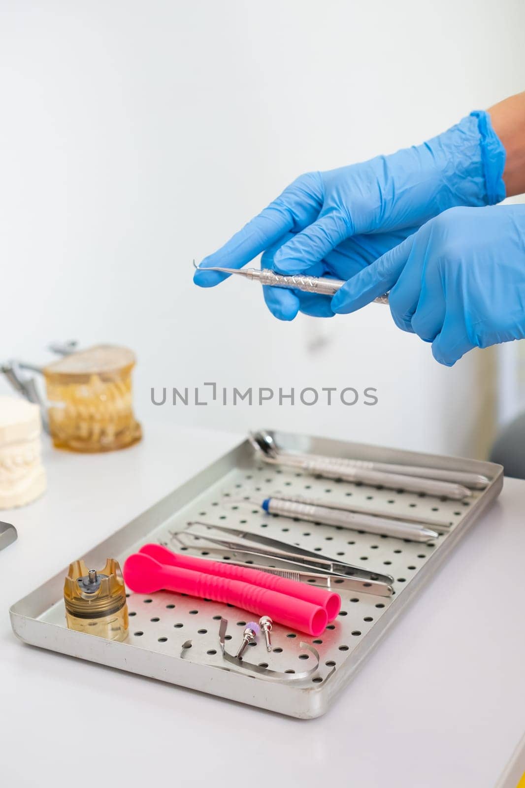 Dentist in rubber gloves takes dental hook for teeth treatment.