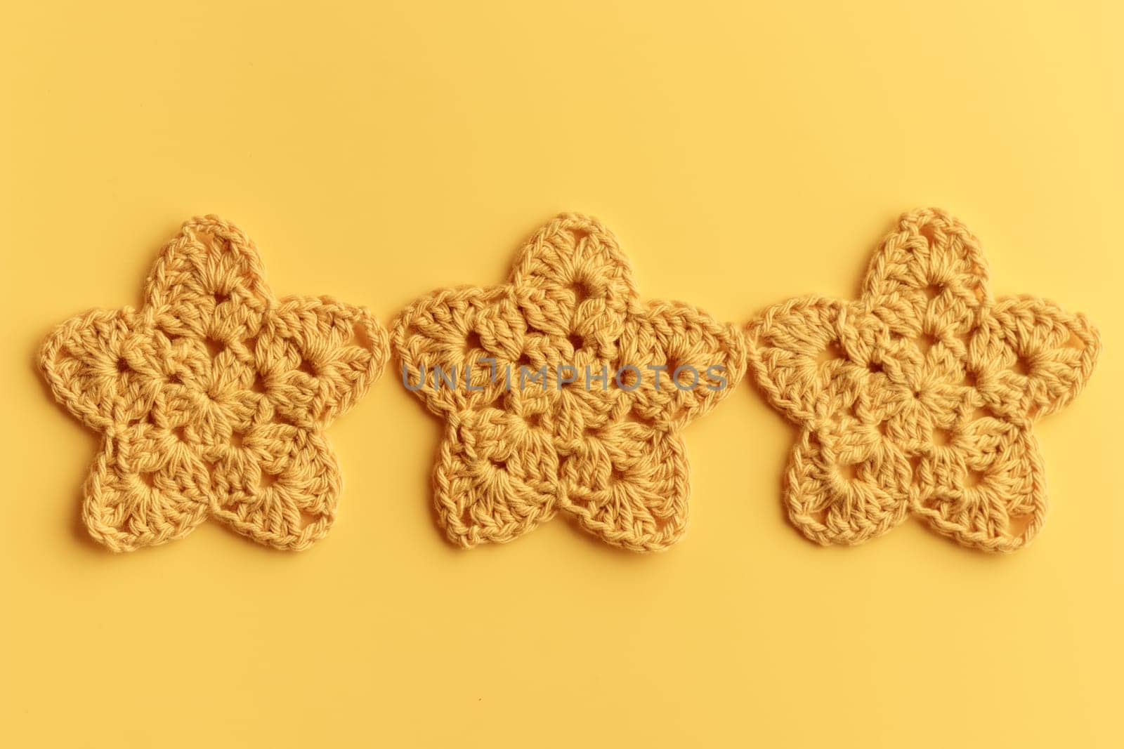 The yellow  crocheted star on a bright background with copy space / pattern