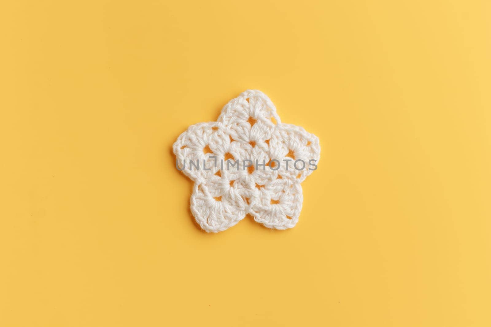 The white  crocheted star on a bright background with copy space / pattern by Gudzar
