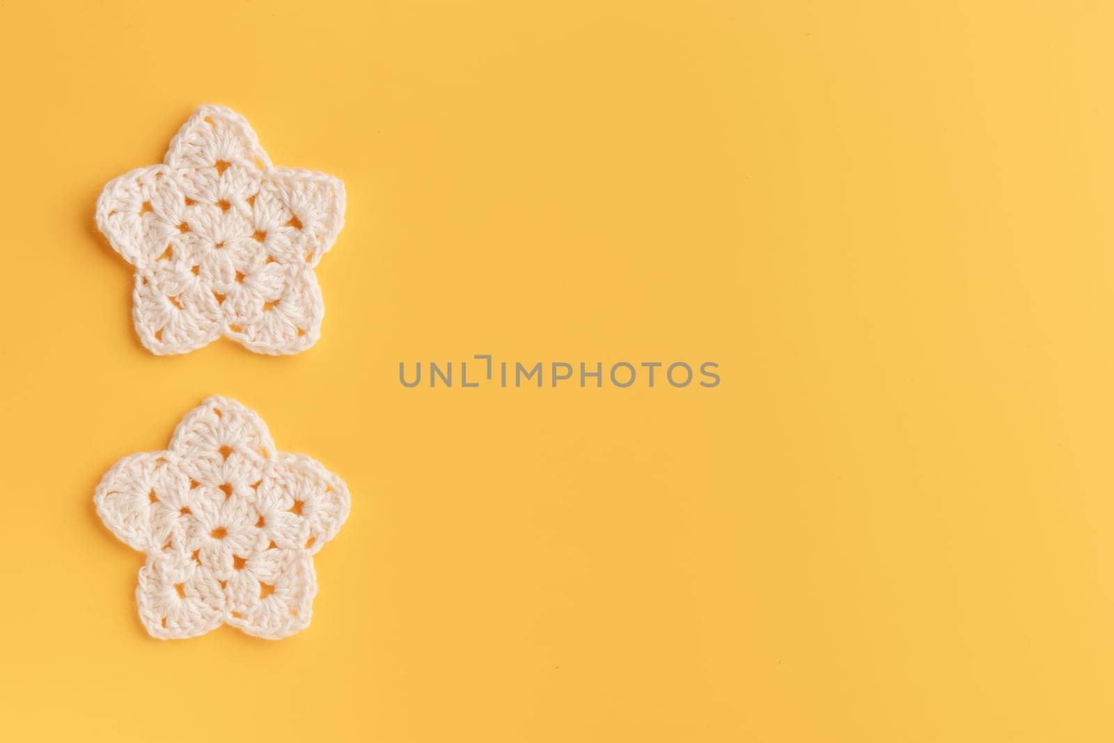 The white crocheted star on a bright background with copy space / pattern
