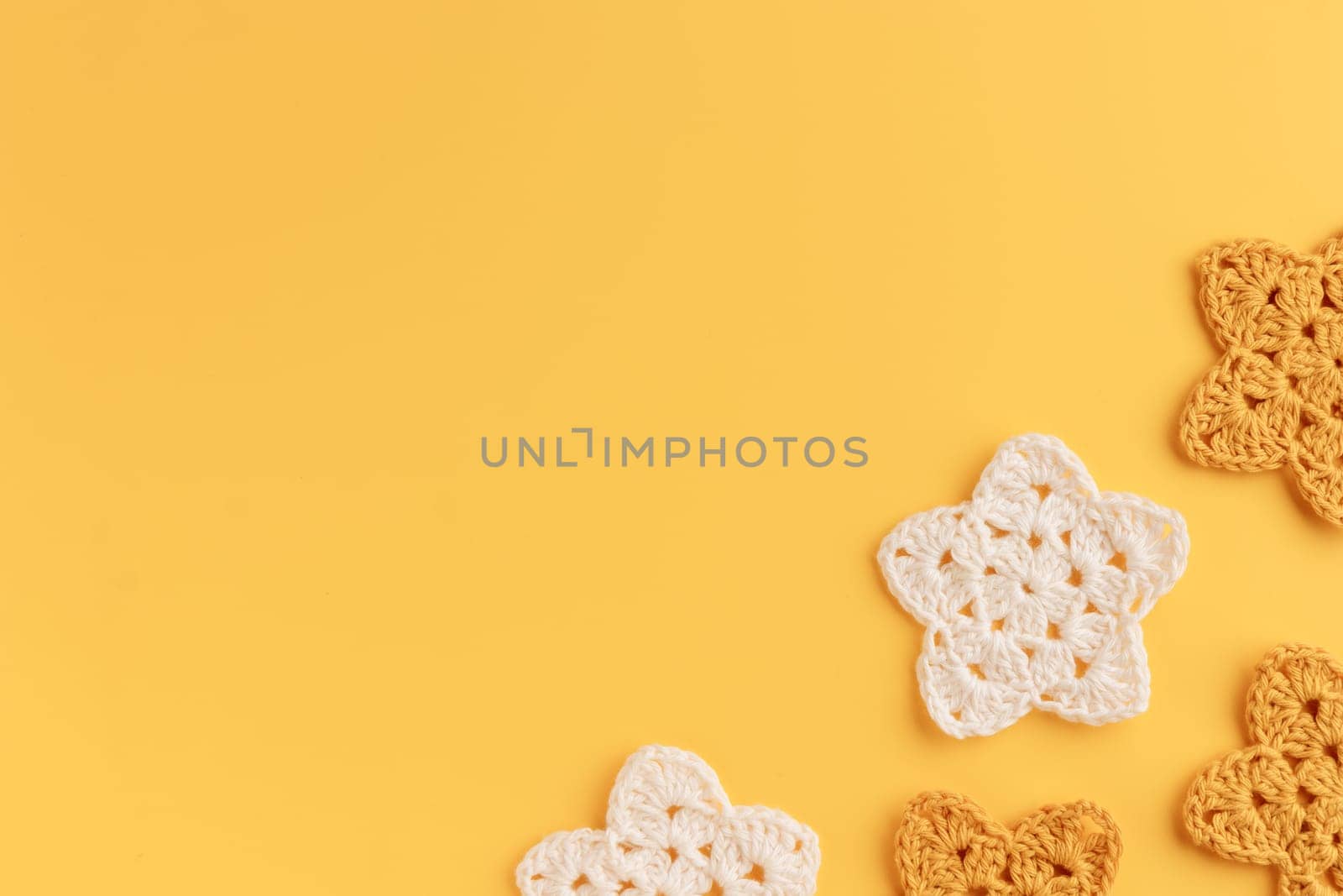 The white and yellow  crocheted star on a bright background with copy space / pattern