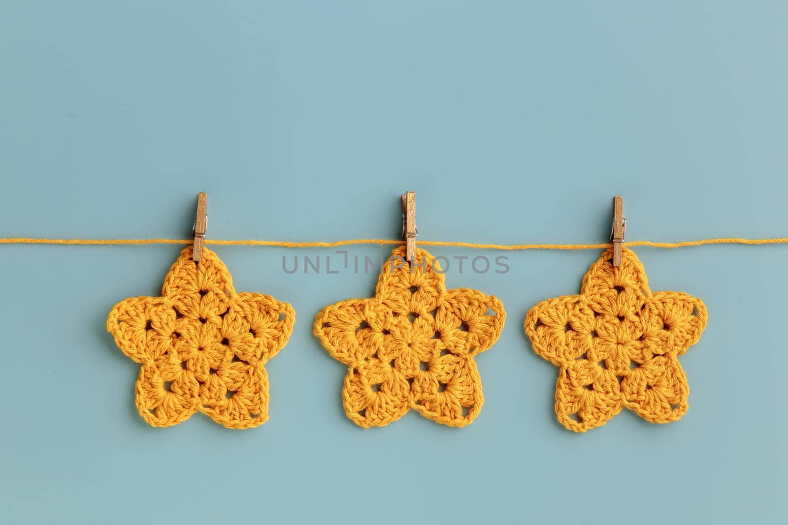 The  yellow  crocheted star on a bright background with copy space / pattern