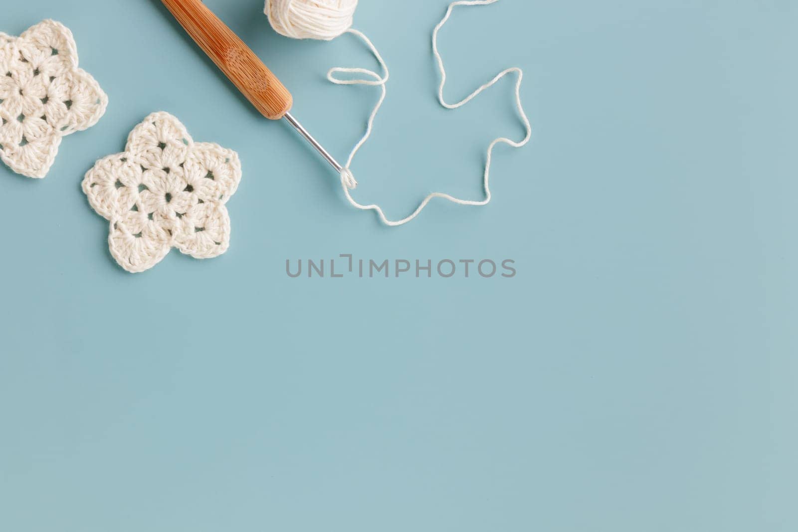 The white and yellow  crocheted star on a bright background with copy space / pattern