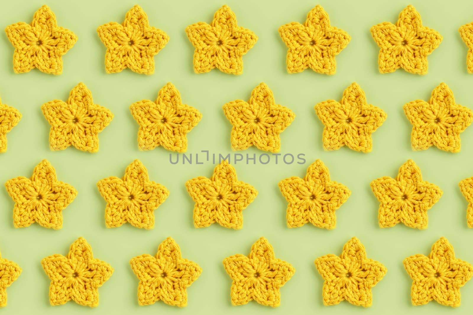 Yellow crocheted stars pattern on a green background