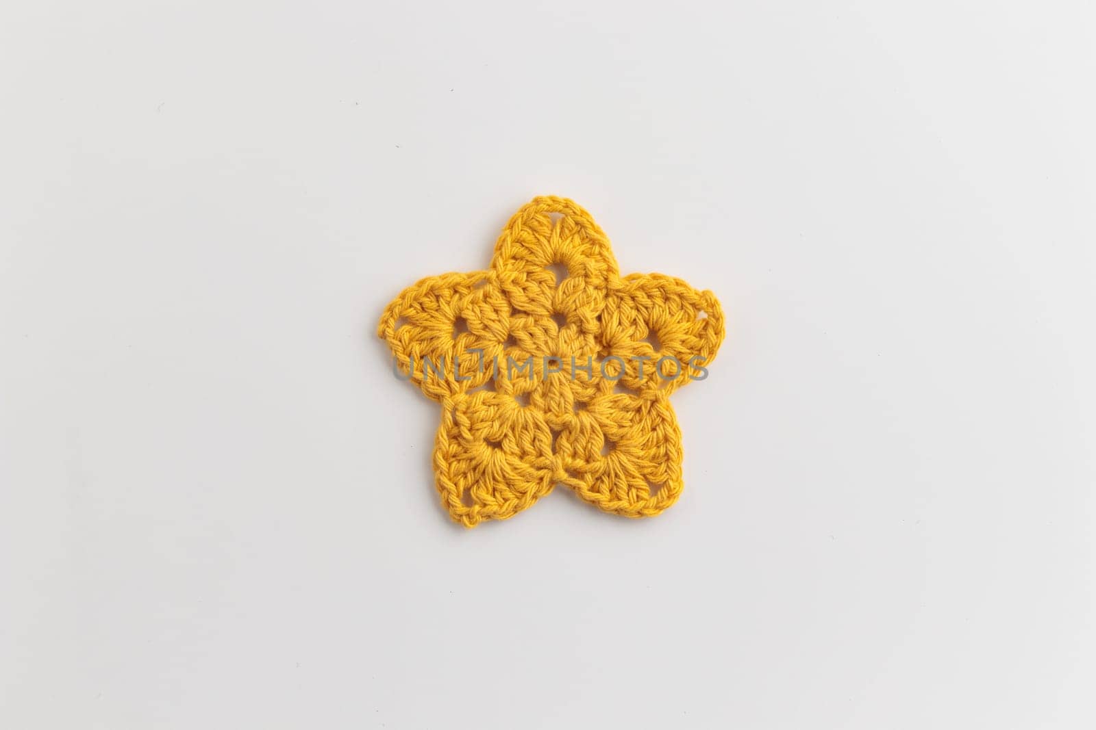 The yellow crocheted star pattern on a white background