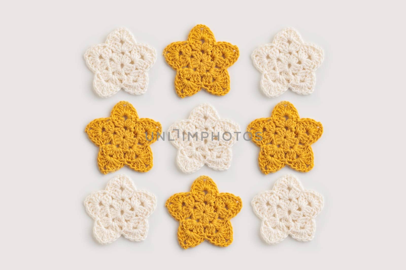 The white and yellow  crocheted star on a bright background with copy space / pattern by Gudzar