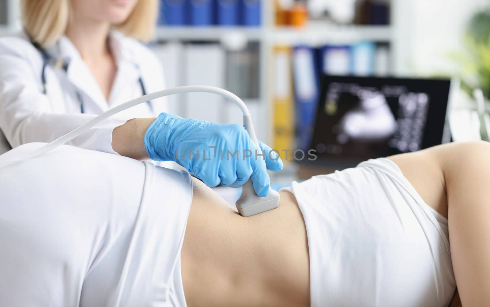 Close-up of professional medical worker examine clients body with ultrasound tool. Pregnant woman on planned checkup. Medicine, scanning, clinic concept