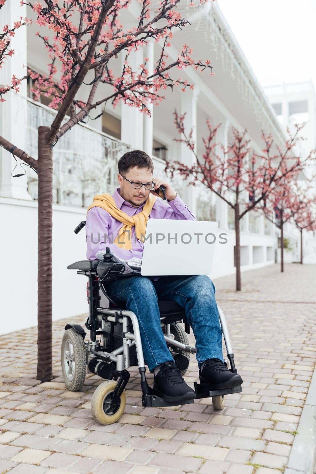 talking on the phone to a special person with disabilities with a laptop by Simakov