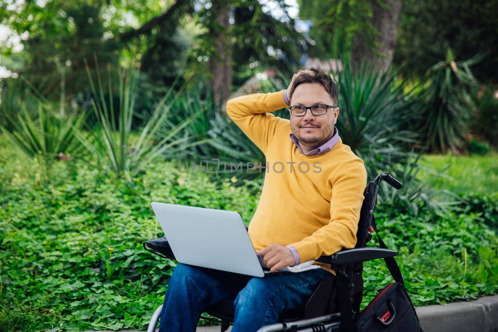 special person with disabilities with a laptop in the park