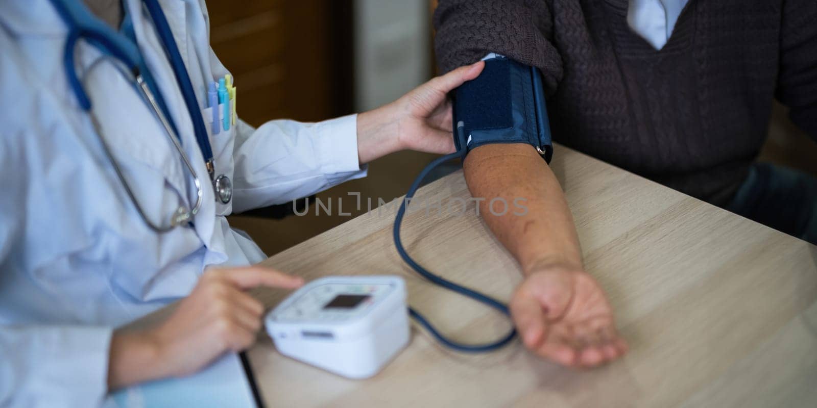 nurse doctor using digital tonometer check blood pressure for old asia female at home in elderly care cardiovascular medical visit, cholesterol problem. Home health care and nursing home concept by nateemee