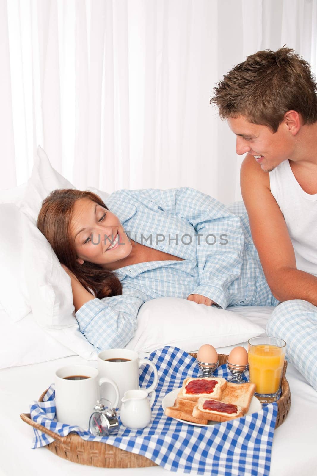 Young couple having breakfast in bed