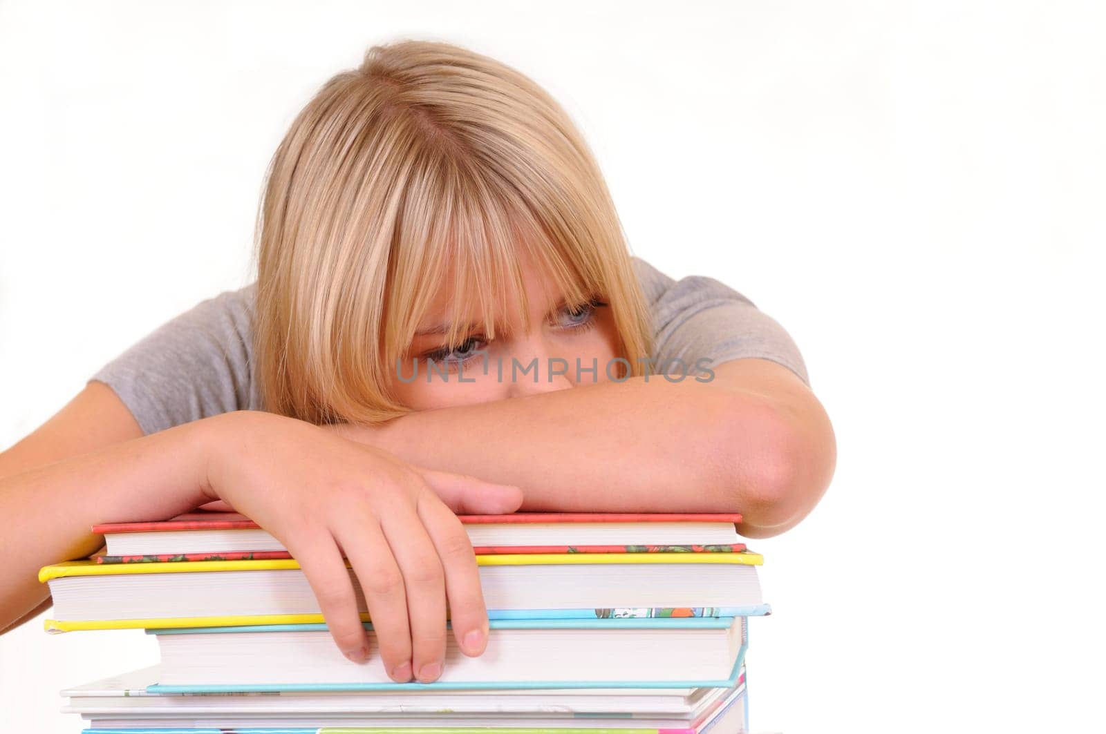 Exhausted young woman on pile of books