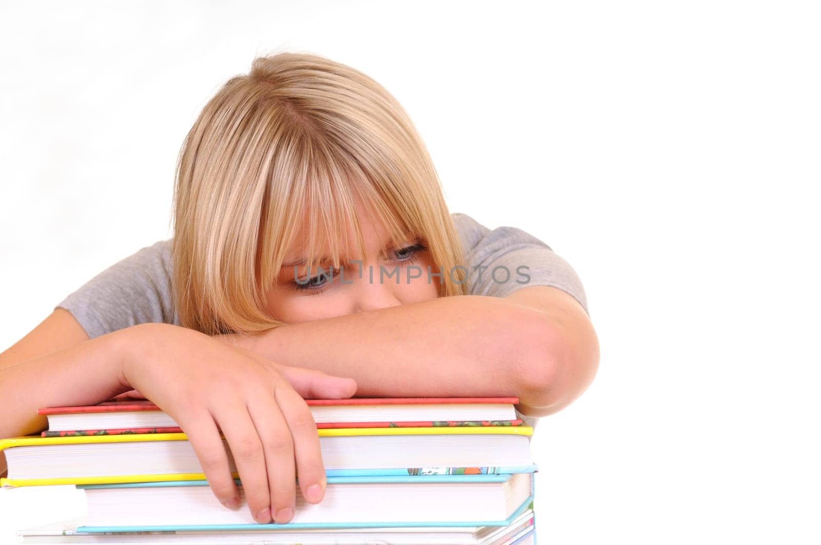 Exhausted young woman on pile of books