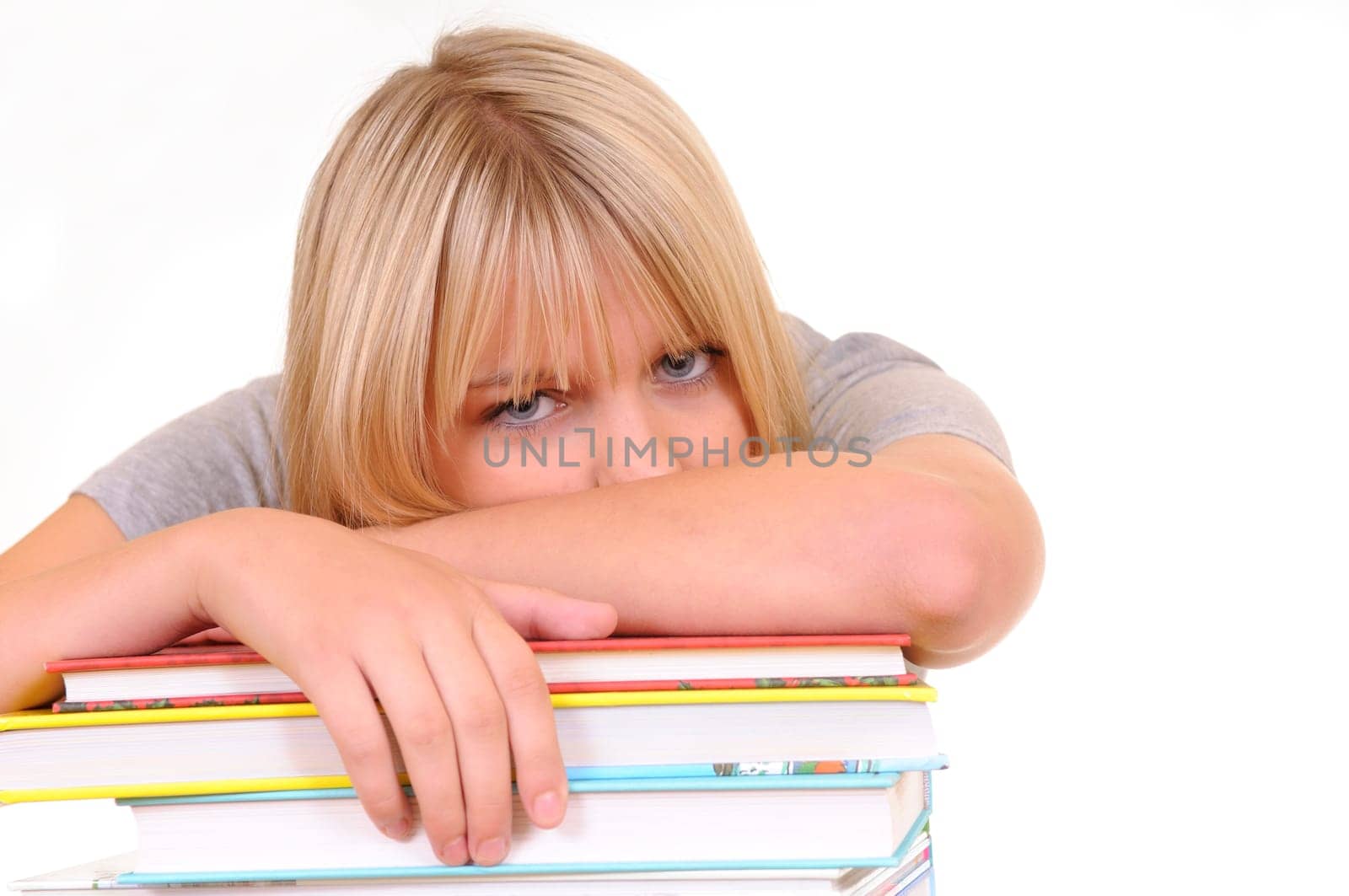 Exhausted young woman on pile of books