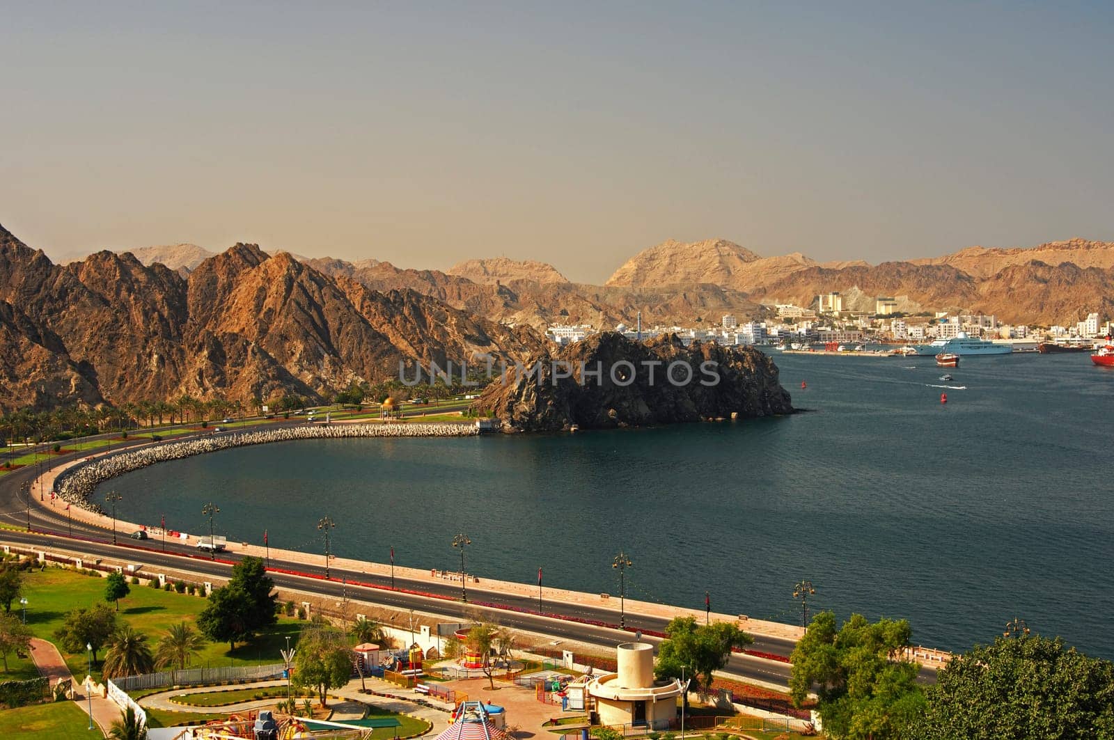 Lakeside street at the harbour basin with a view of the Muttrah district in front of the bare Be