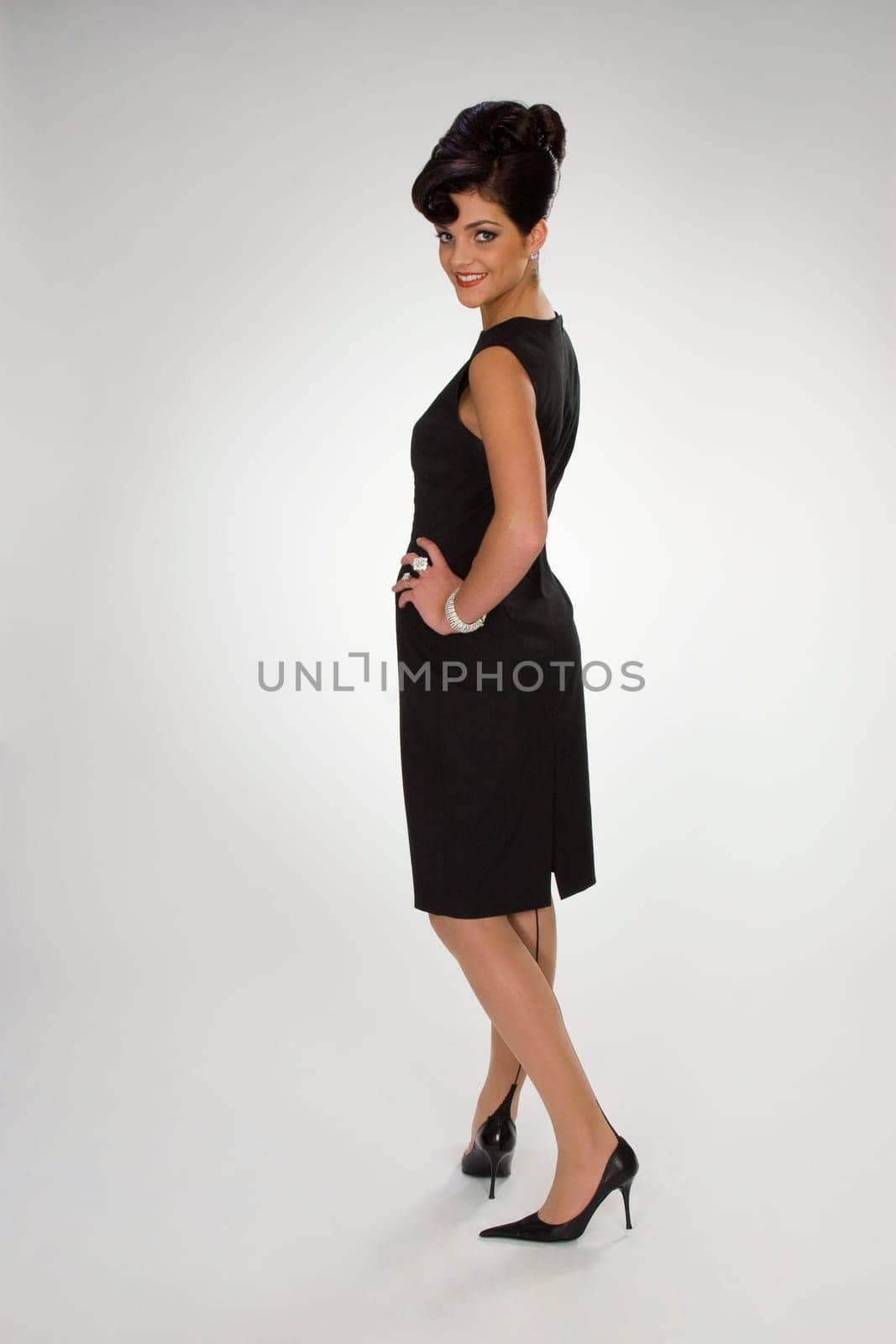 Beautiful girl in black dress on grey ba