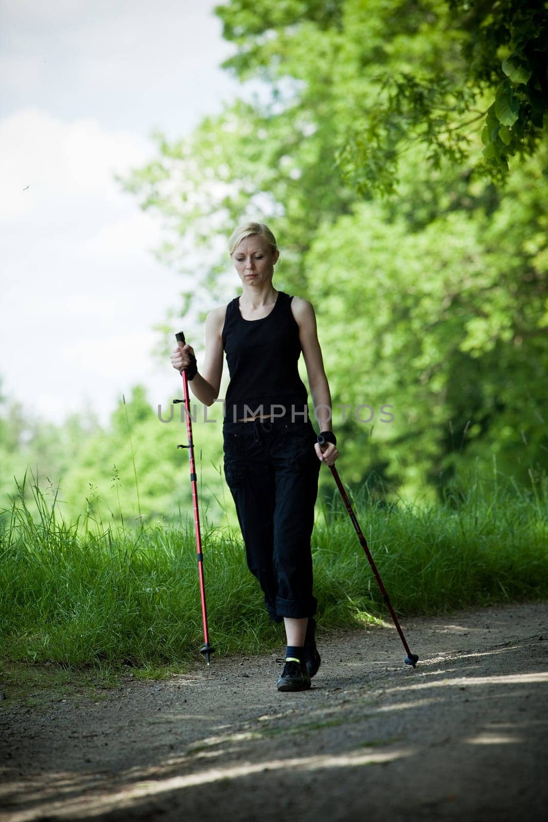 Nordic Walking - young woman is hiking