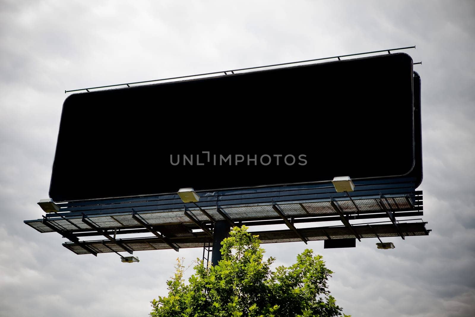 Black blank advertising billboard over sky