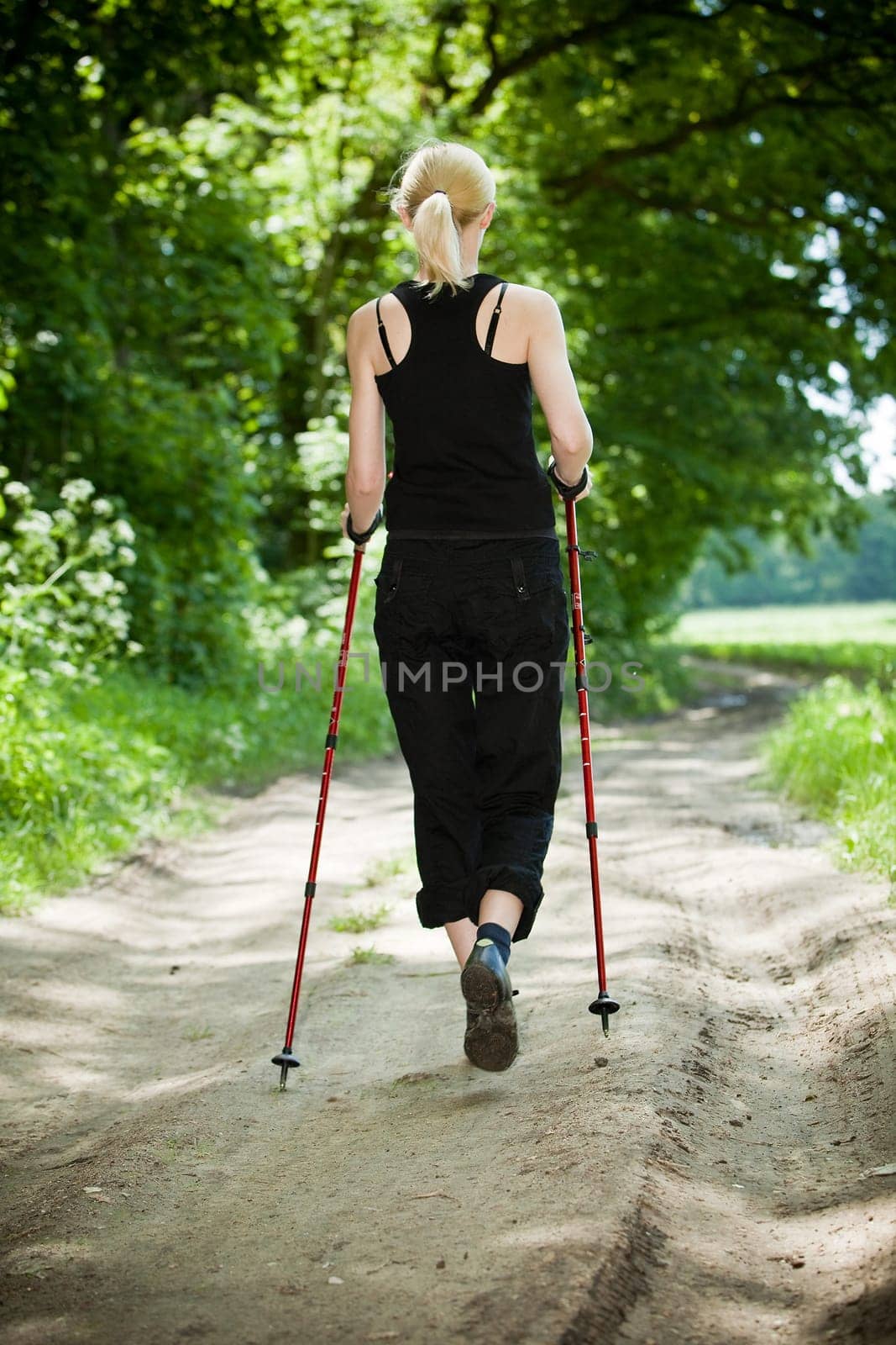 Nordic Walking - young woman is hiking
